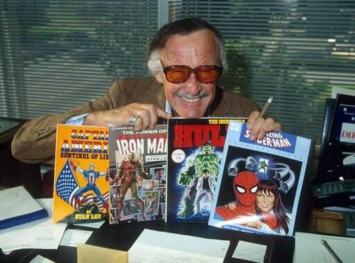 Stan Lee posando con algunos comics antiguos